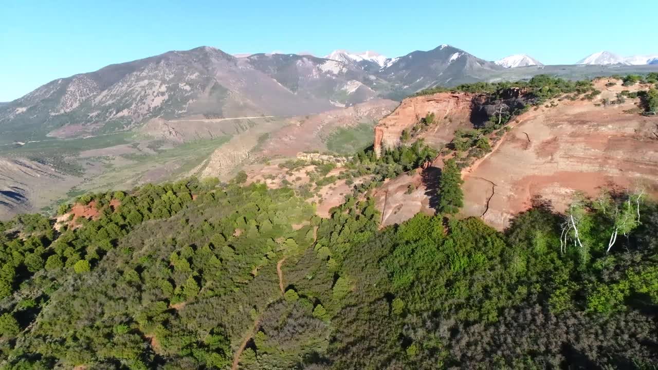 panorámica aérea de izquierda a derecha cerca de moab, utah, que muestra el valle del castillo, senderos, montañas, hoodoos y bosques