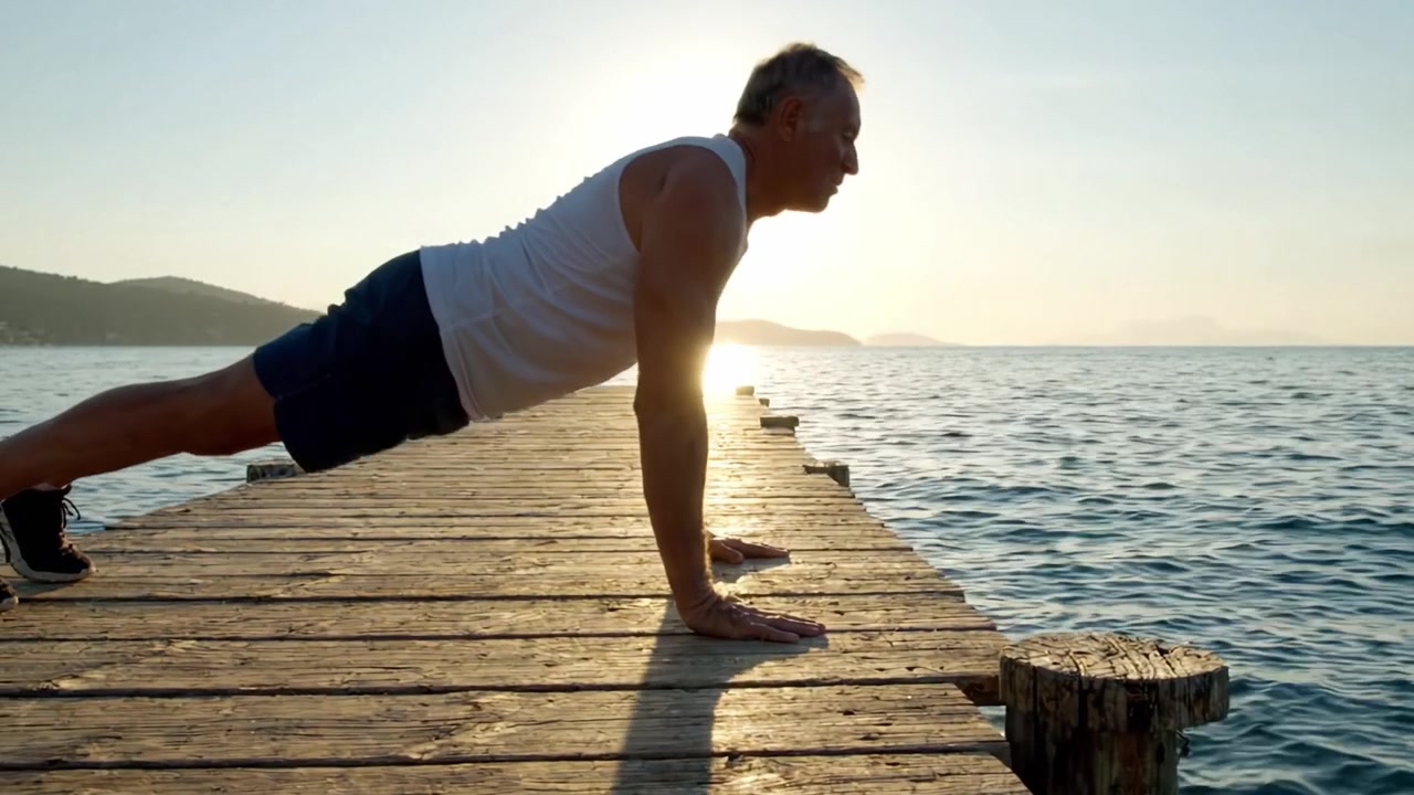 An Individual Practicing Push-Ups on a Serene Pier at Sunset with Calm Waters in the Background, Emphasizing Strength, Balance, and Wellness in Nature