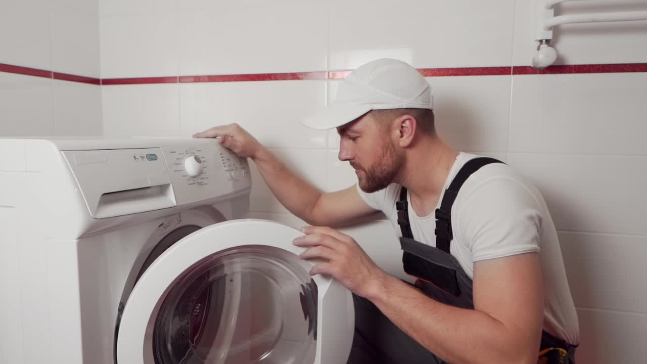 un idraulico professionista mostra che è necessaria una nuova lavatrice