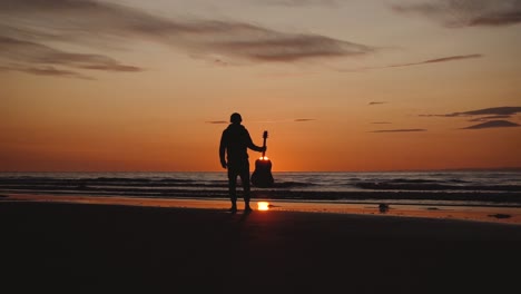 man running with guitar in back sand beach at sunset-17