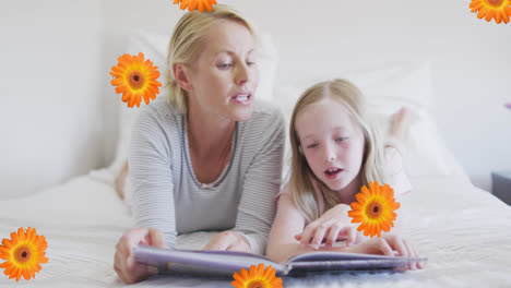 animation of flowers over caucasian mother and daughter reading book in bed