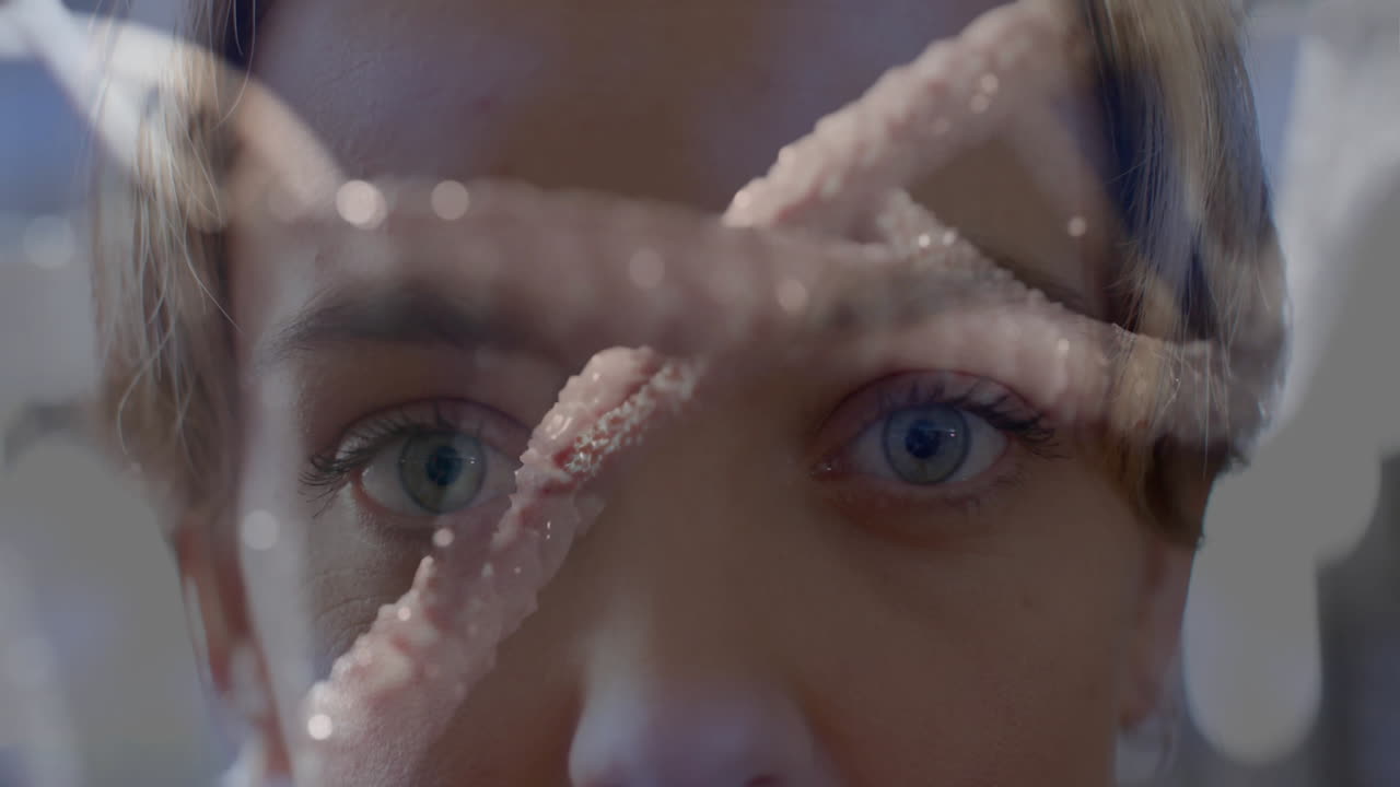 DNA strand animation over close-up of person face with blue eyes