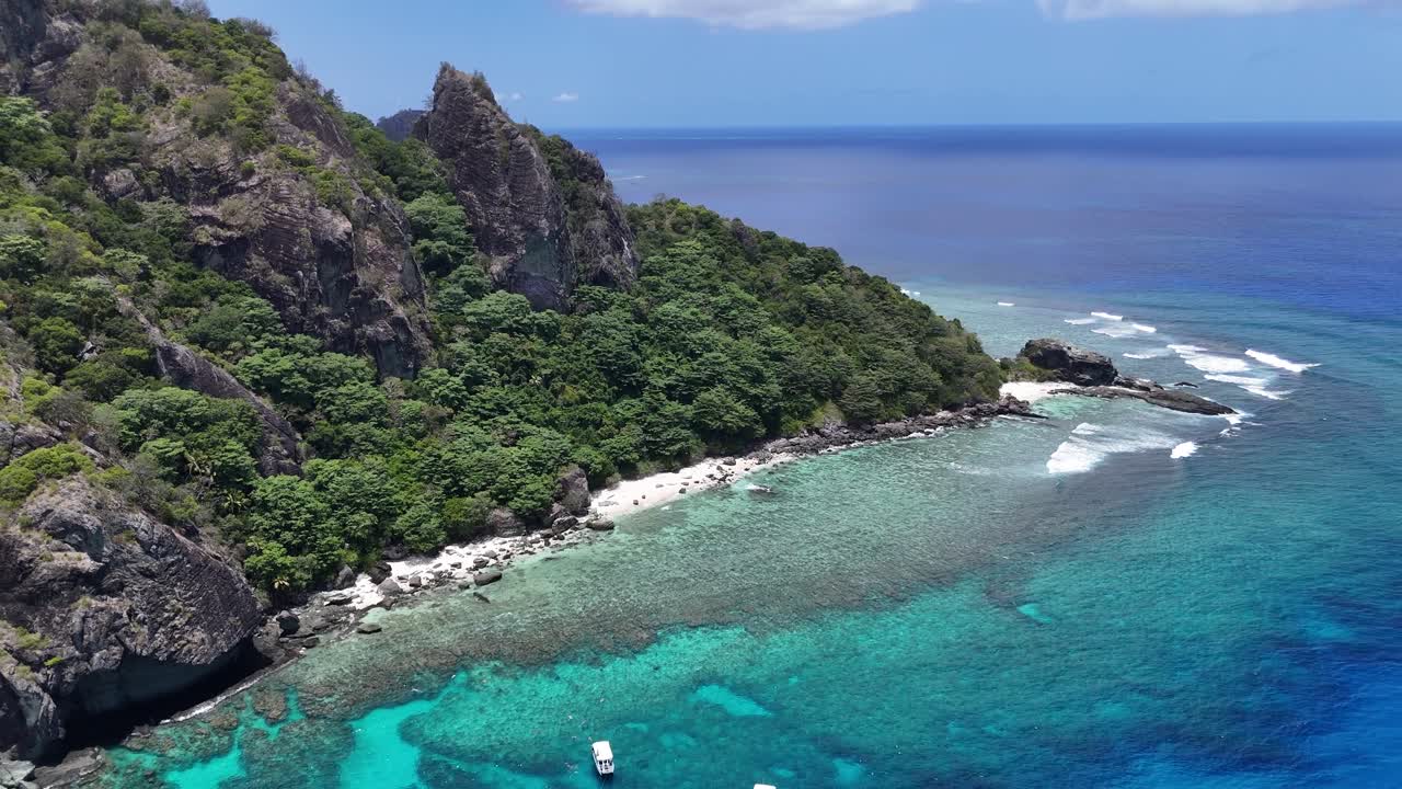 Vista aerea da drone di una spiaggia di sabbia bianca incontaminata sull'isola di Castaway, nelle Figi. Le vivaci acque turchesi e la lussureggiante vegetazione tropicale creano un perfetto paradiso del Pacifico meridionale