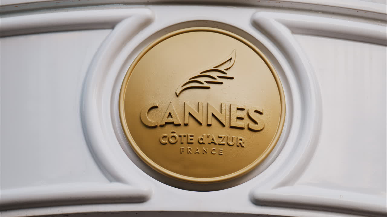 Close up of a white, rotating signboard with the words Cannes in France