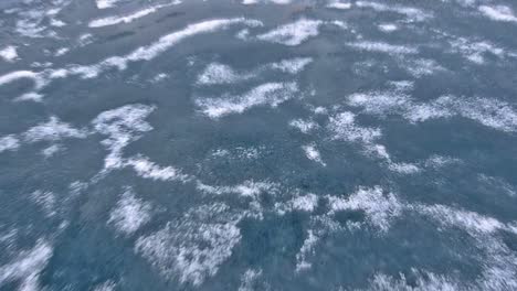 Tilt-down-bow-point-of-view-of-an-icebreaker-ship-plowing-through-sea-ice-in-Hinlopen-Strait-in-Svalbard-Archipelago-Norway