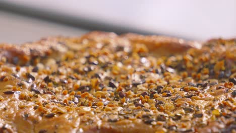 close up details of chicken and mushroom pie fresh out the oven with seeds dressed over the top as focus moves across rustic texture of dish. british cuisine winter food