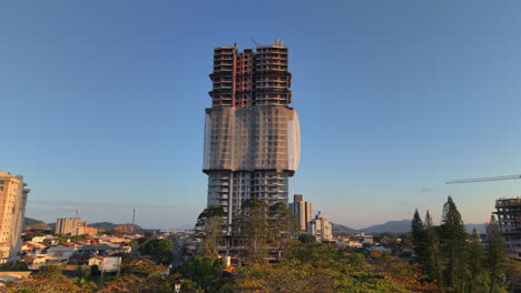 aerial view of towering skyscraper under construction with security mesh. penha, brazil