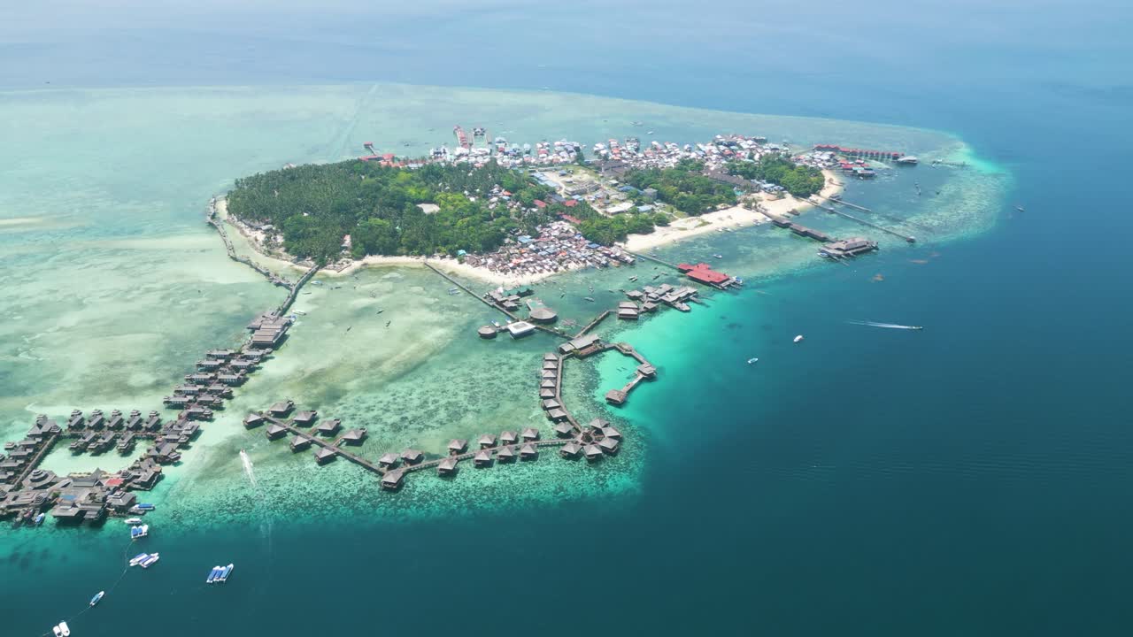 Aerial of Sabah's Mabul Island, captivating scenery of the Bajau community and the Water Village Resort, presenting a dynamic tapestry of life in this coastal haven of Malaysia