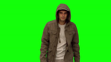 man with a coat walking toward camera on green screen