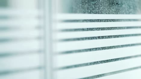figura masculina mirando a través de la ventana