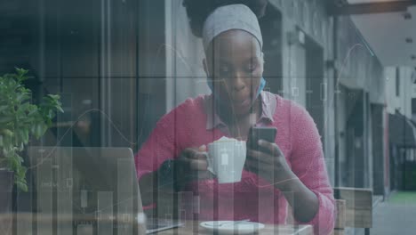 Animation-of-graphs-over-african-american-woman-using-cellphone-while-drinking-coffee-at-cafes