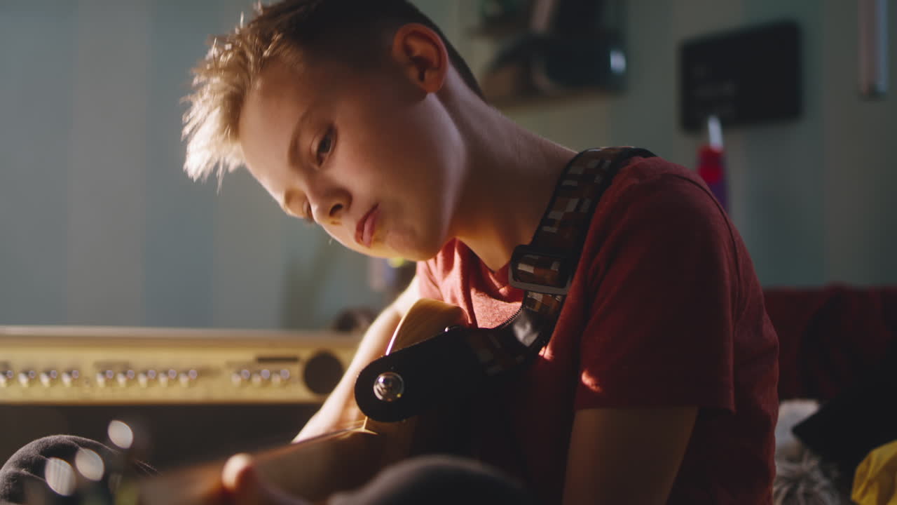 Young boy playing guitar at home
