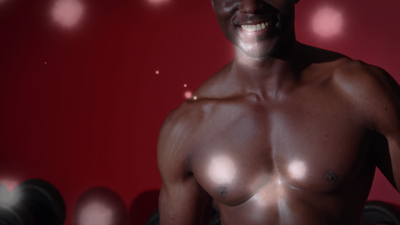 animación de manchas brillantes sobre un hombre fuerte haciendo ejercicio en el gimnasio