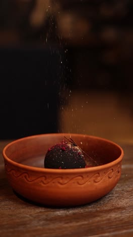 postre de esfera de chocolate oscuro con salpicaduras