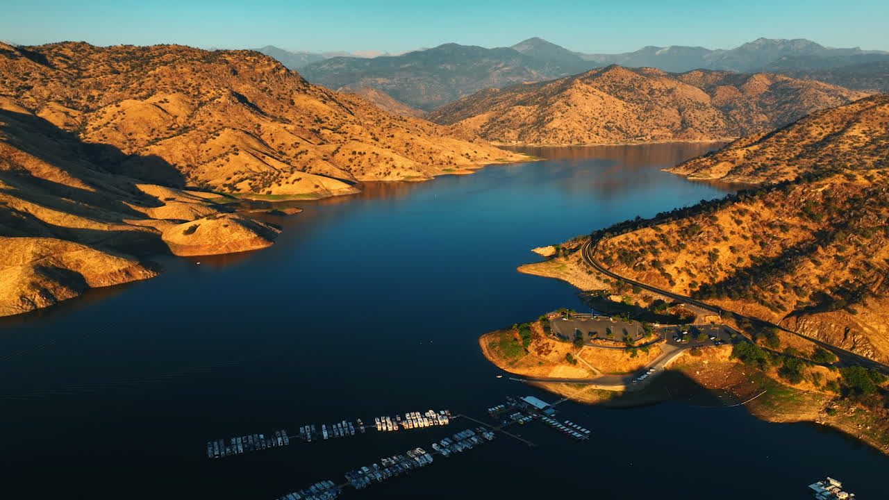 Multiple yacht at the dock on the calm lake. Gorgeous sunlit bare mountains around the lake. Top view.