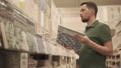 man choosing tiles at a home improvement store