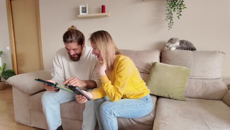 a couple uses technology at home with their cat