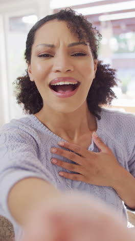 video vertical del retrato de una feliz mujer afroamericana haciendo una llamada de video