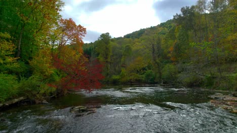 El-Dron-Se-Desliza-Sobre-Un-Río-En-Las-Montañas-De-Carolina-Del-Norte-En-El-Otoño-Con-Hojas-Coloridas-Pintadas-En-El-Fondo