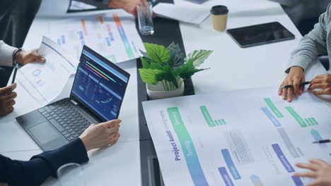 multi-ethnic office conference room businesspeople meeting at big table. diverse team of creative entrepreneurs talk, find solution. specialists work in digital e-commerce startup. focus on hands