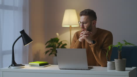 Gutaussehender-Mann-Mit-Brille-Sitzt-Allein-Im-Zimmer-Vor-Dem-Laptop-Und-Denkt-Nach,-Männliches-Porträt-Zu-Hause-Am-Abend,-Freiberuflicher-Schriftsteller-Oder-Journalist