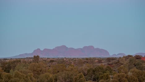 un lapso de tiempo de una puesta de luna llena detrás de kata-tjuta poco antes del amanecer en el interior australiano