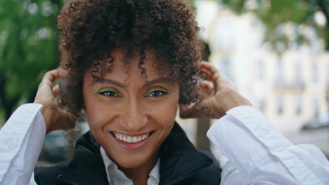 Woman-taking-off-headphones-looking-camera-with-smile-close-up.-Lady-portrait.