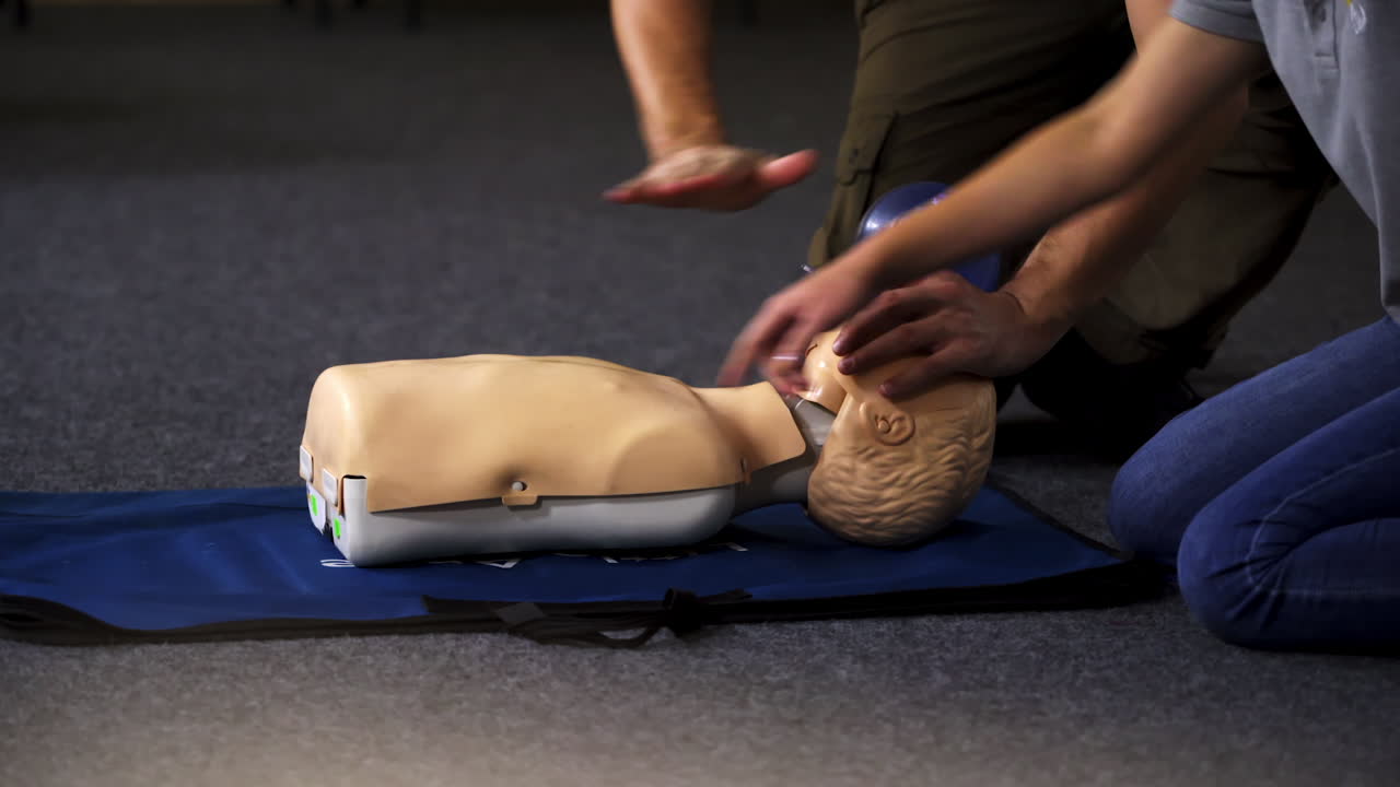 Medical training on a dummy. Instructor and practitioner near the mannequin. Practical exercise with breathing apparatus for giving first aid.
