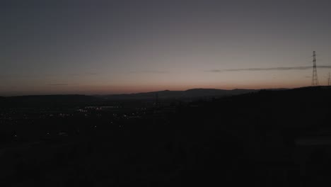 Vista-Aérea-Nocturna-Del-Centro-Urbano-De-Lisboa-Con-Luces-Brillantes-En-Las-Casas-Al-Atardecer