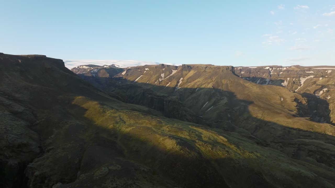 vista de avión no tripulado de las tierras altas de islandia con acantilados escarpados, valles escarpados y sombras dramáticas proyectadas sobre el paisaje bajo cielos despejados