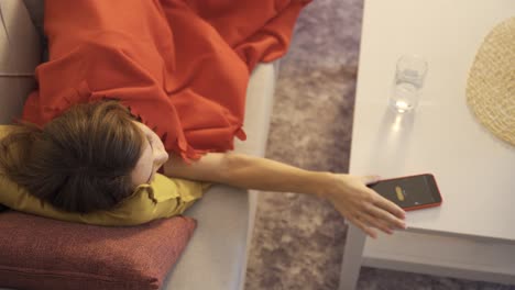 la mujer perezosa se despierta y apaga el despertador del teléfono inteligente.