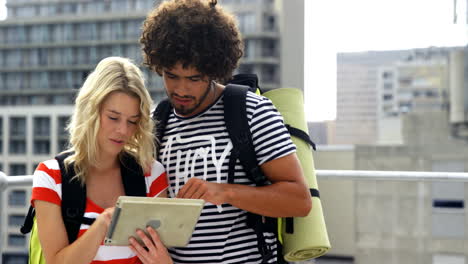 pareja de dos hipsters dirigiéndose hacia con la tableta de computadora