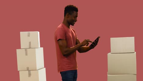 Animation-of-man-using-tablet-with-stacks-of-boxes-on-red-background