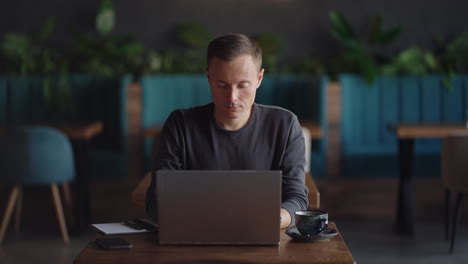 beautiful male developer or student working studying by laptop in cafe. freelance remote work online education self employed