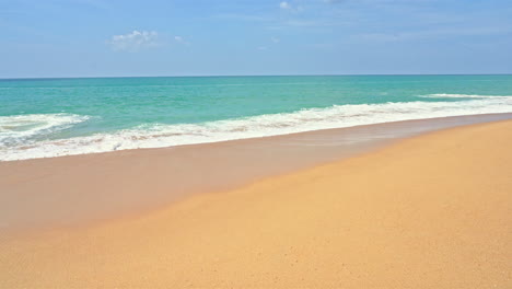 slow-motion waves wash up on a golden sand beach