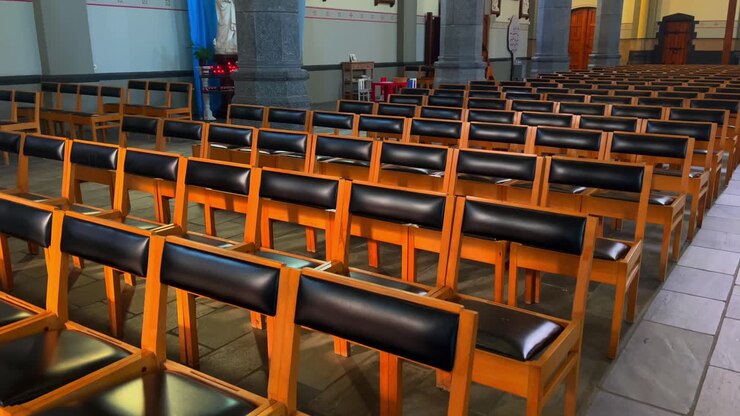Row of chairs for audience and churchgoer and worshipper in Catholic Belgian church