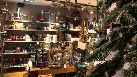 snowy decorated christmas fir tree in shop with santa claus gifts,candles and advent wreath for a beautiful interior home