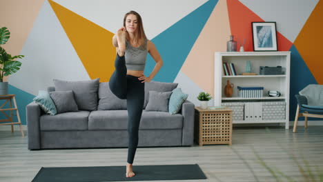 mujer practicando una postura de yoga en casa