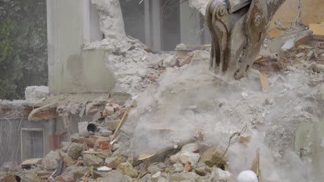 demolition of a building with bulldozer arm