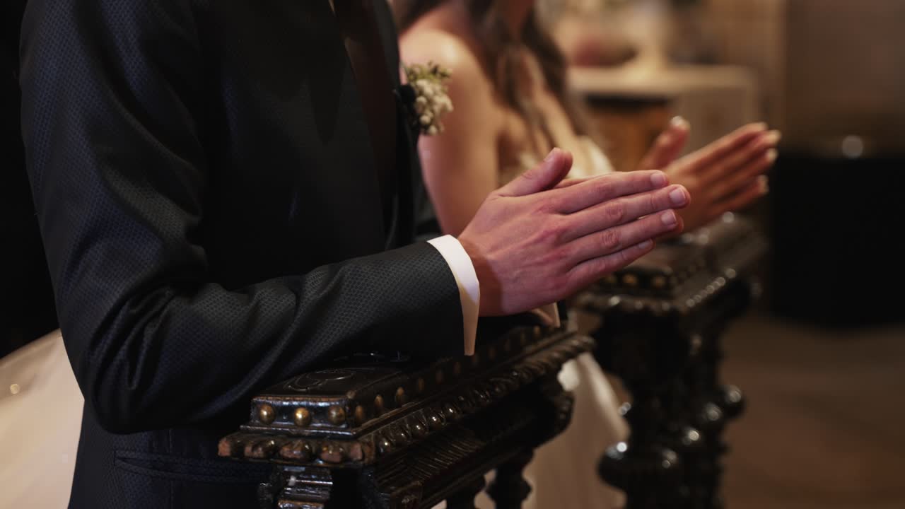 우아한 결혼식 도중 제단에서 기도하는 커플의 클로즈업