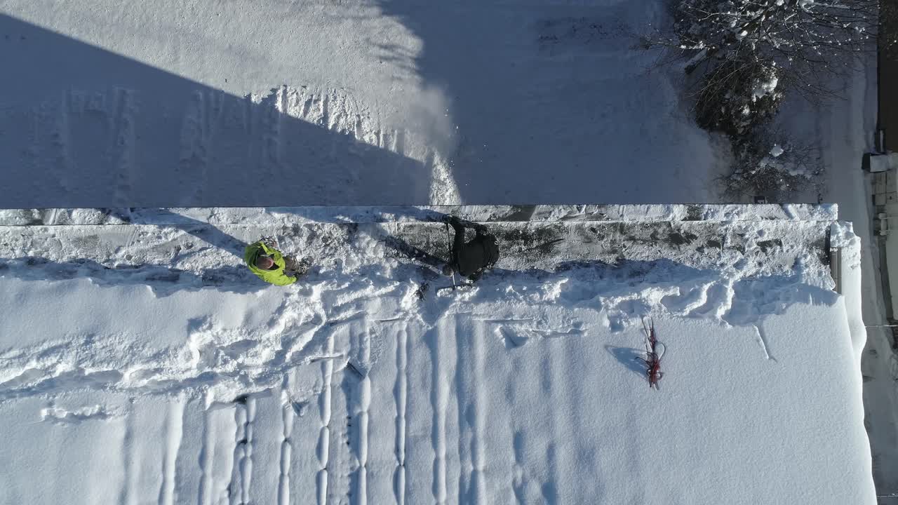 la gente quita la nieve en la azotea con una pala en la ciudad de zakopane, polonia