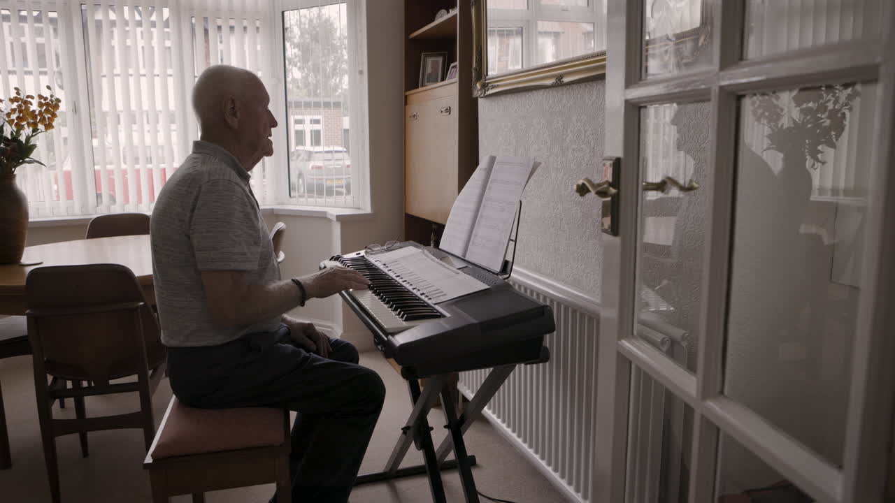 Senior man playing keyboard at home
