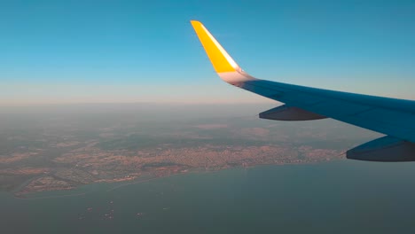 airplane wing on the horizon line and the port on the way to marseille with the ships in the sea