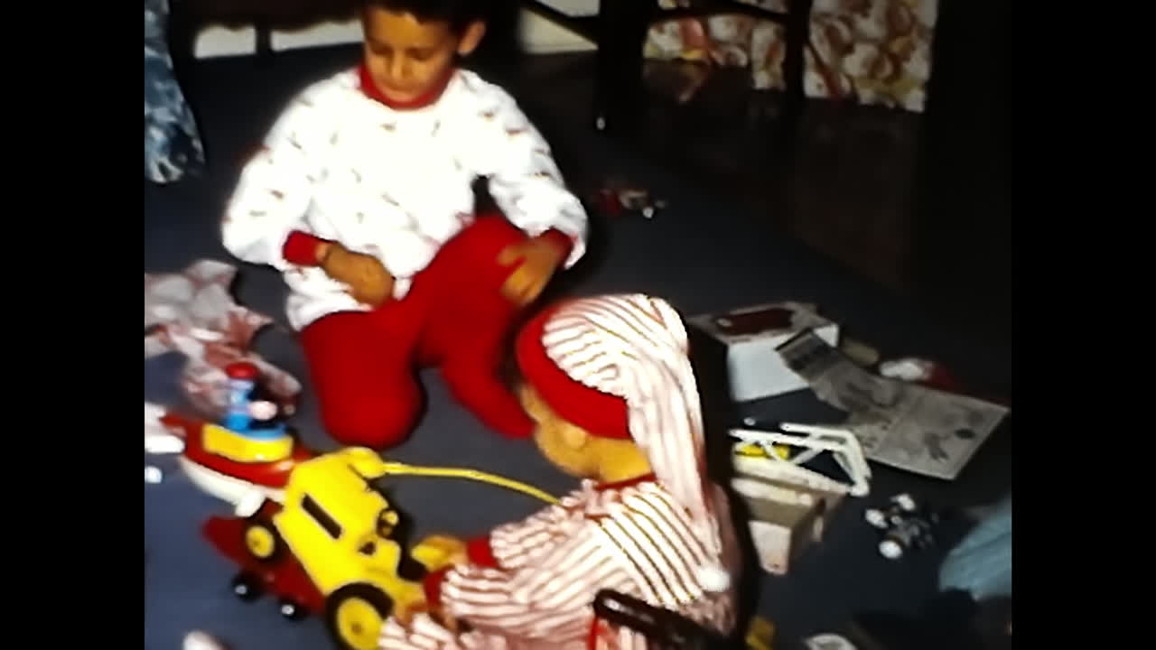 Children Playing With Toys on the Floor. CIRCA USA - 1970s: Two children from a 1970s video archive in the USA are seen playing together on the floor with various toys.