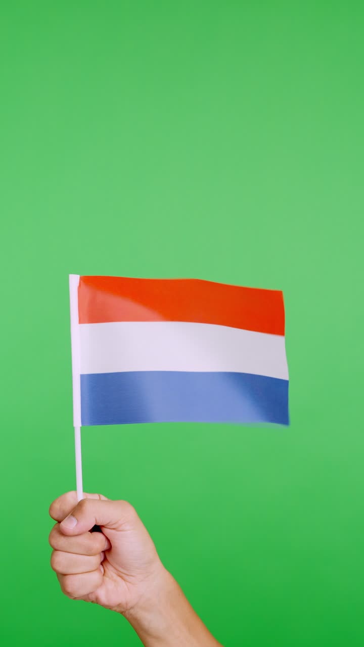 Hand lifting a dutch pennant while waving by the wind