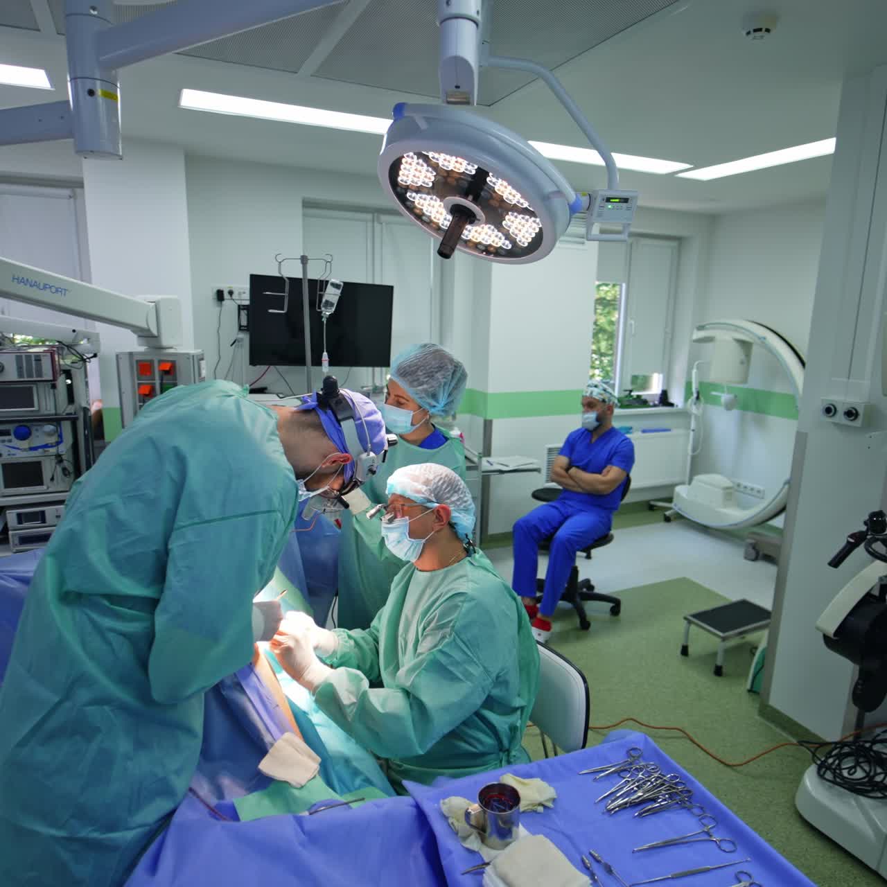 Spacious well-equipped surgery room with surgical procedure in process. Circle movement around doctors' team busy with procedure
