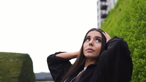 la modelo caucásica con grandes ojos de chocolate y cabello castaño muestra una variedad de expresiones faciales confiadas posando sonriendo y luciendo lindas en la naturaleza con clima nublado