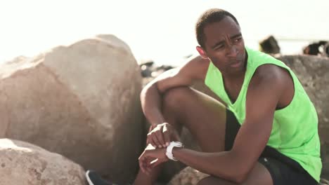 man using smartwatch on the beach