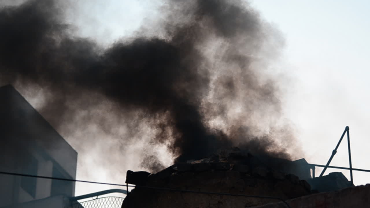 대낮 야외에서 집 외부에서 나오는 불타는 집 어두운 검은 연기