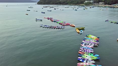 a dynamic orbiting aerial footage of various boats and kayaks near the beach of sai kung town in hong kong